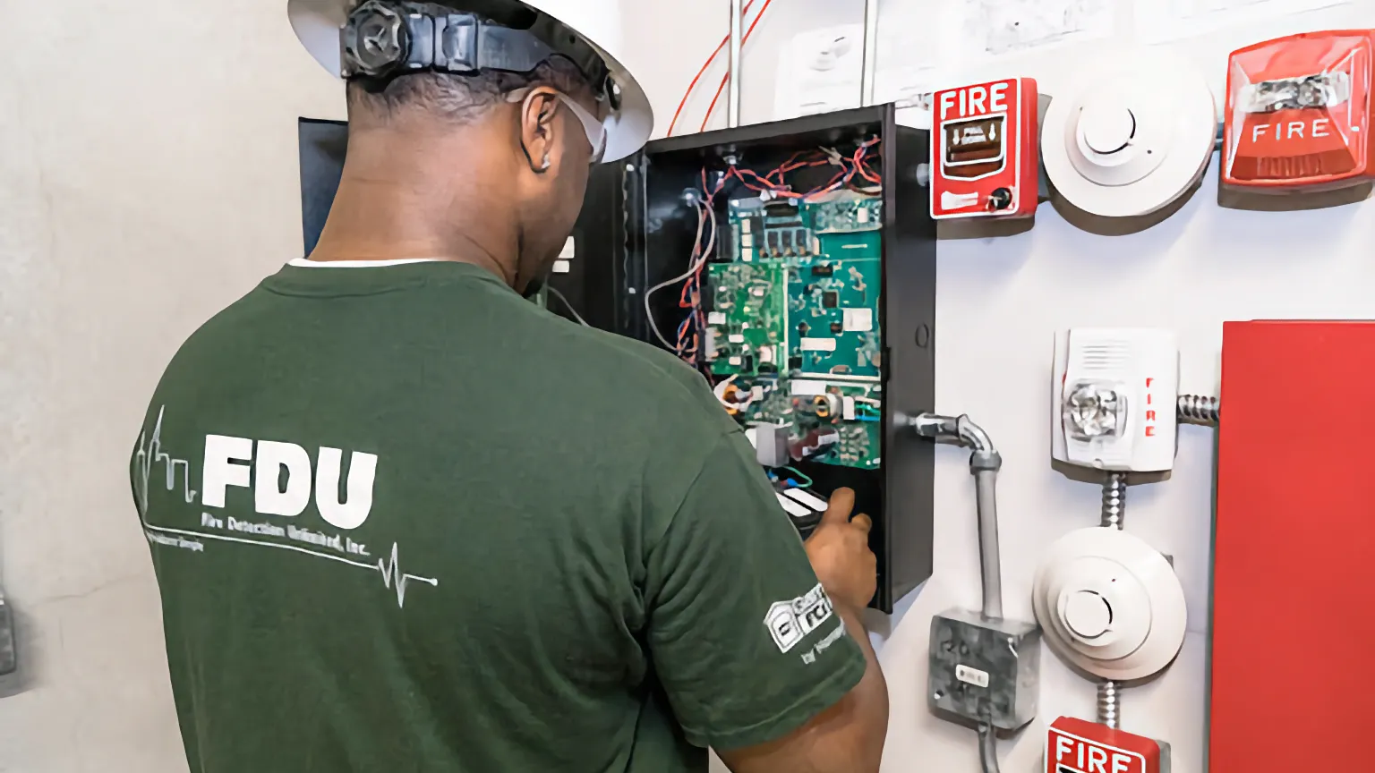 A man inspecting a fire alarm system