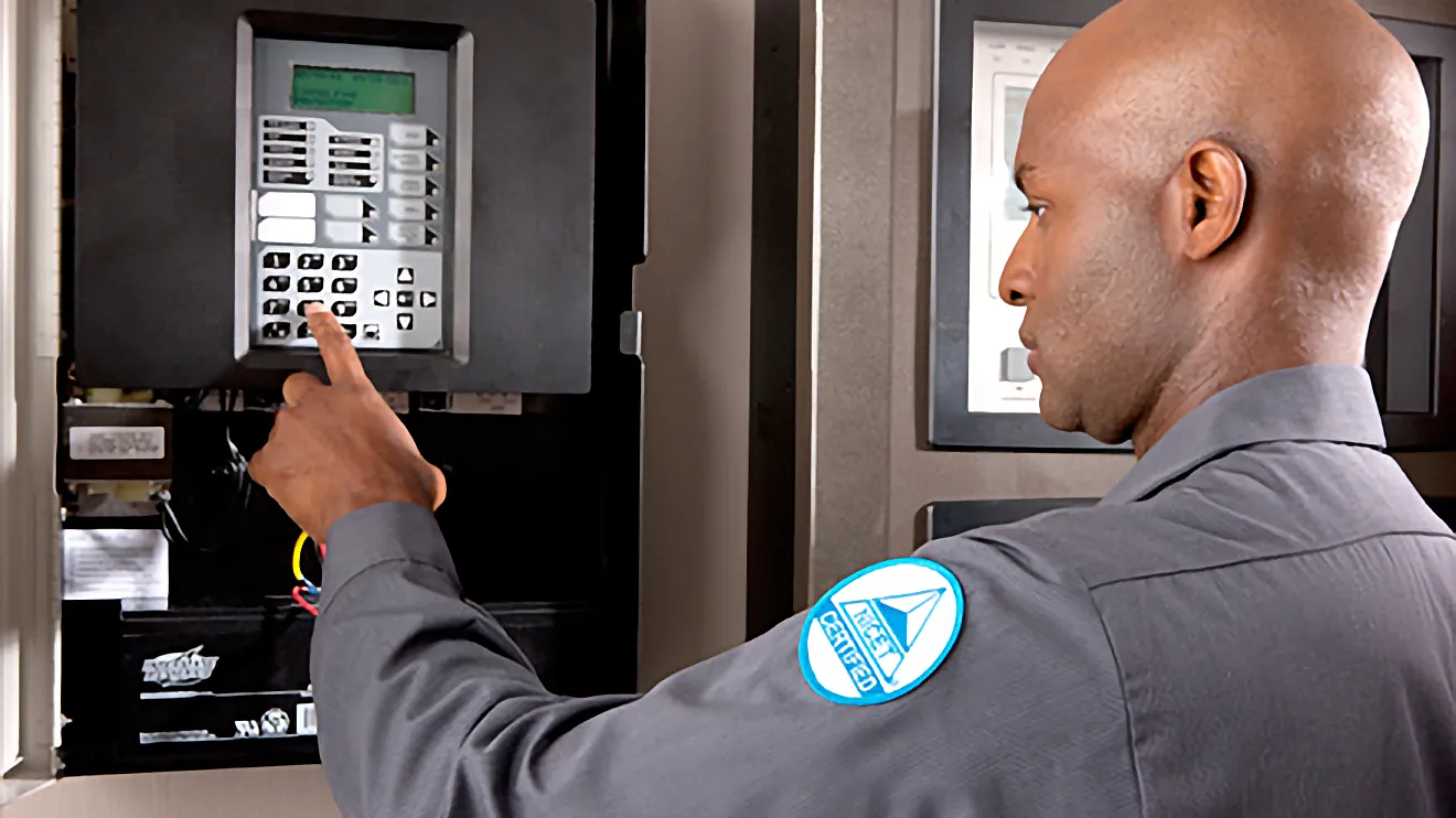 A man testing a fire alarm system